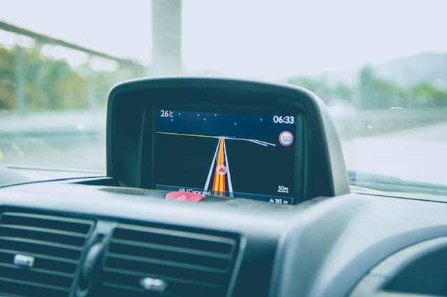 In-vehicle navigation screen showing a route on a rainy day